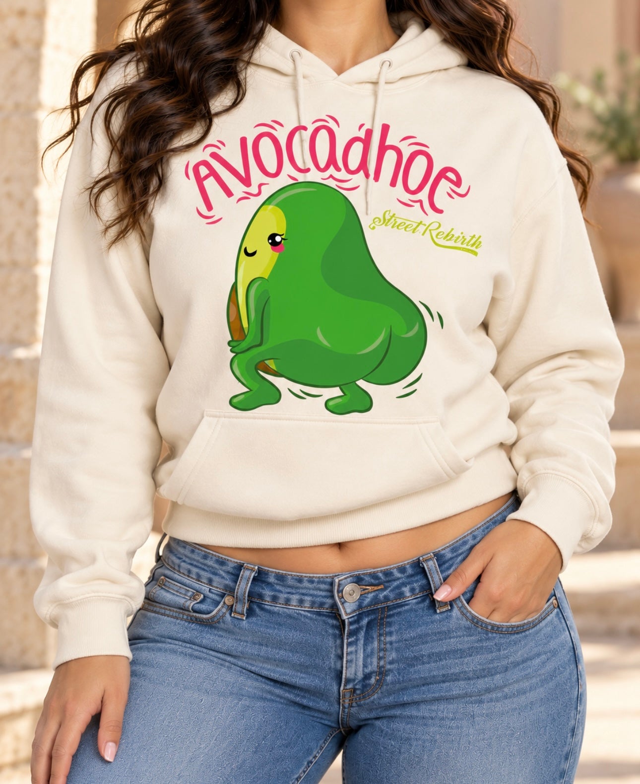 Lifestyle model wearing cream Avocadhoe graphic pullover hoodie with blue jeans