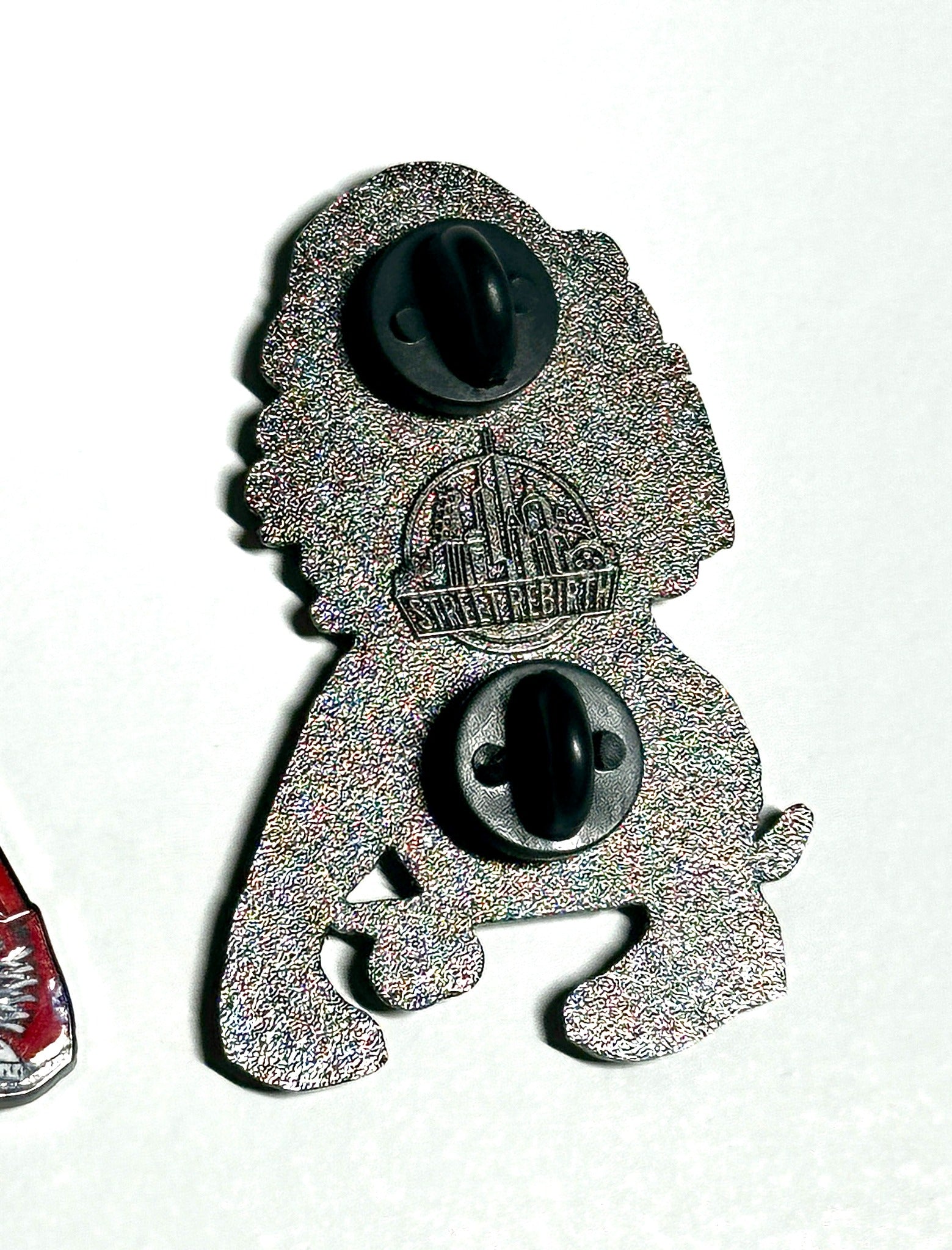 Silver metal two-post backing of bubblegum skater enamel pin