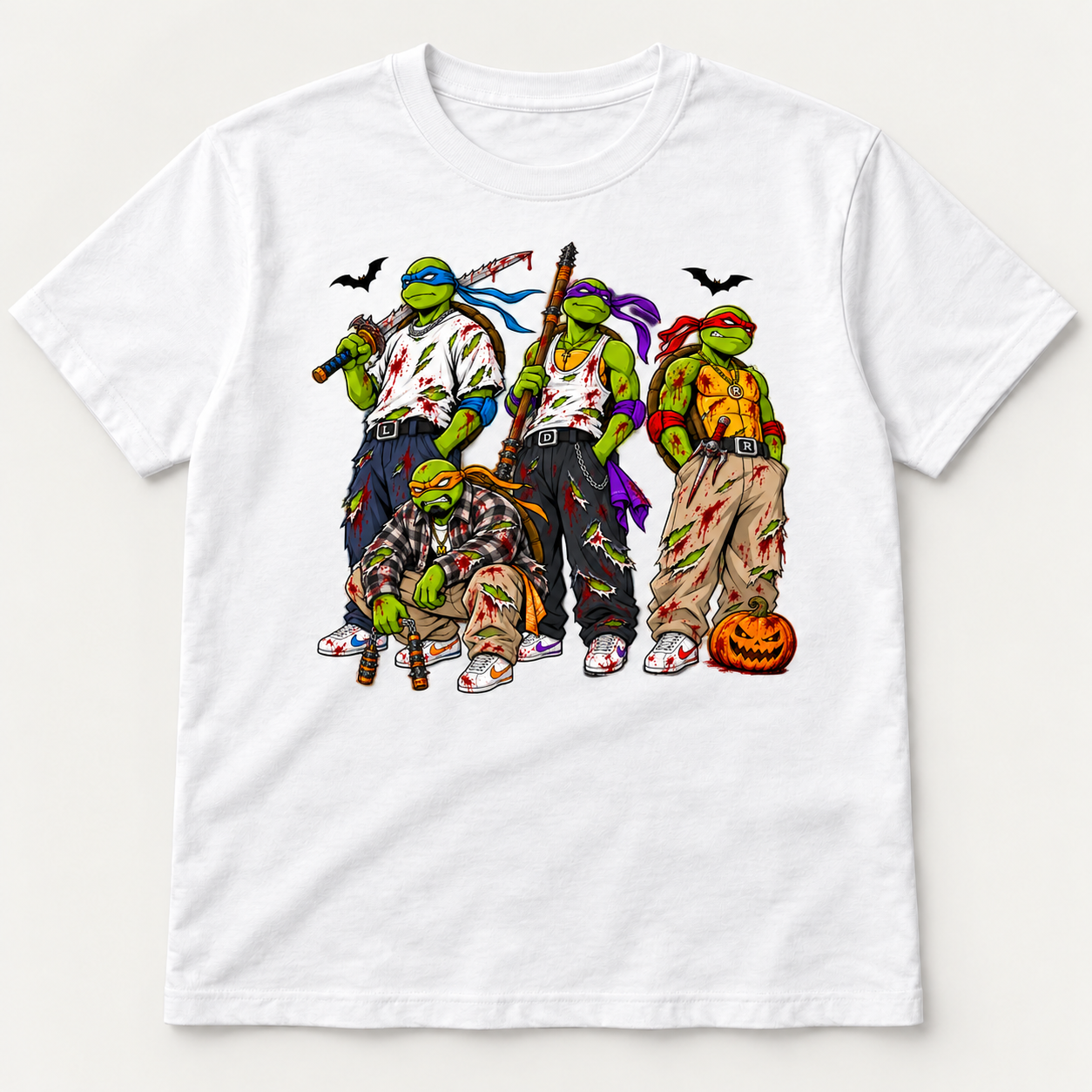 White graphic T-shirt featuring four masked green turtles in torn streetwear, red splatter, bats and an orange pumpkin.