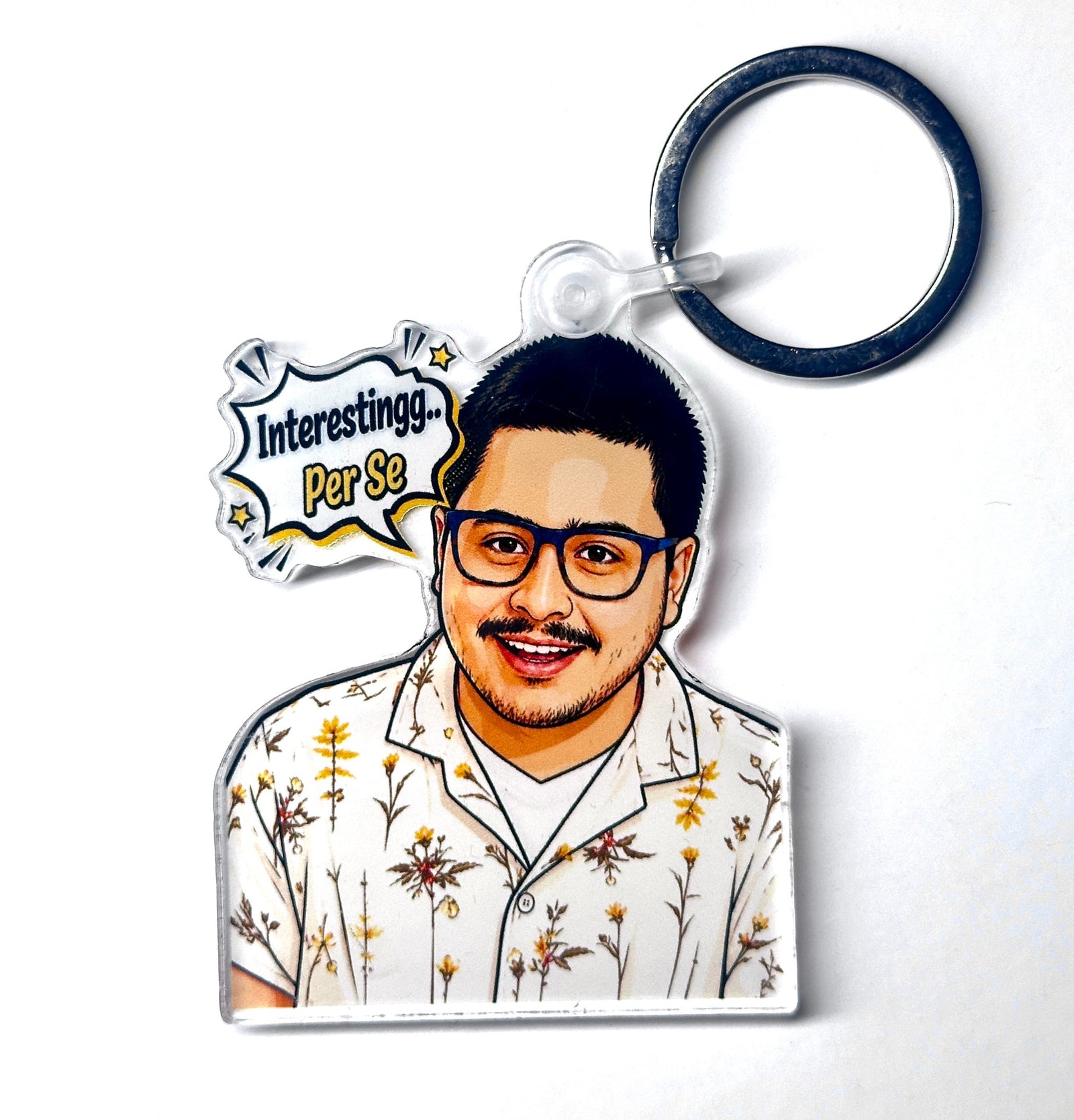 Funny reaction portrait acrylic keychain with glasses, floral shirt, and speech bubble reading Interestingg Per Se, front product photo