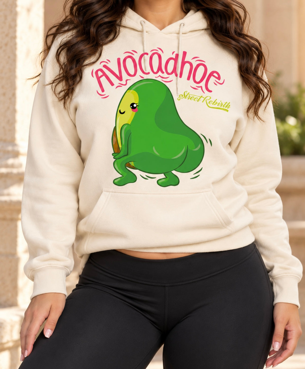 Lifestyle model wearing cream Avocadhoe graphic pullover hoodie with black leggings