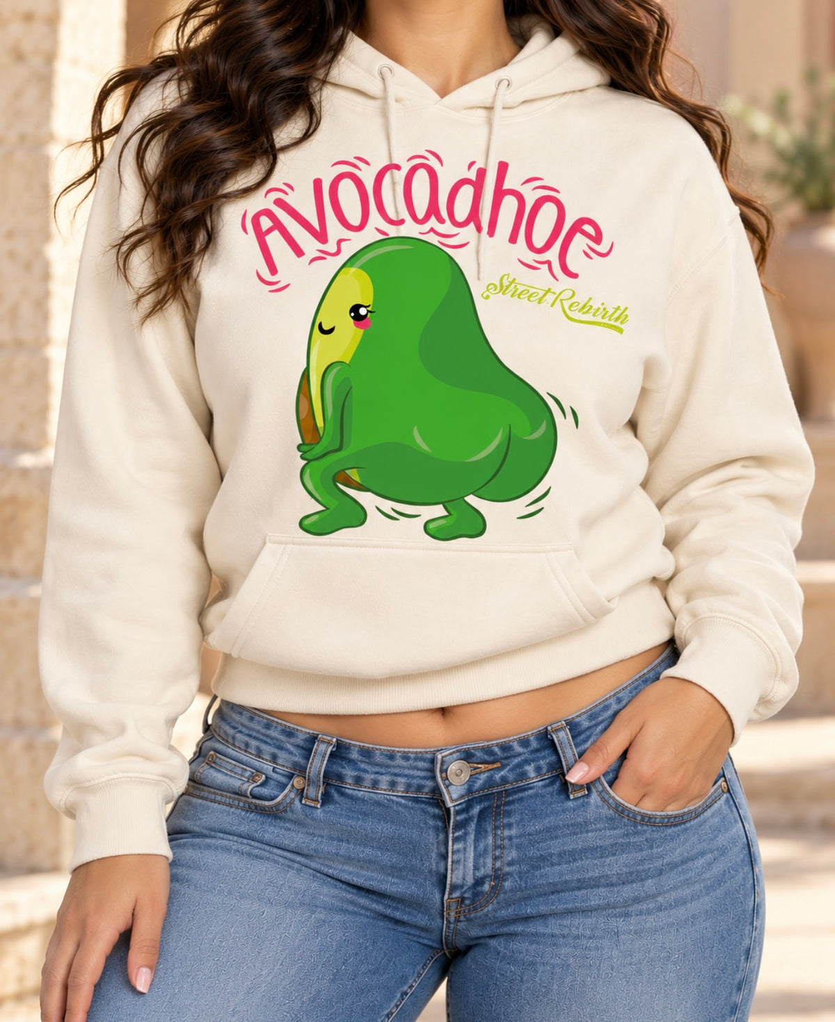 Lifestyle model wearing cream Avocadhoe graphic pullover hoodie with blue jeans