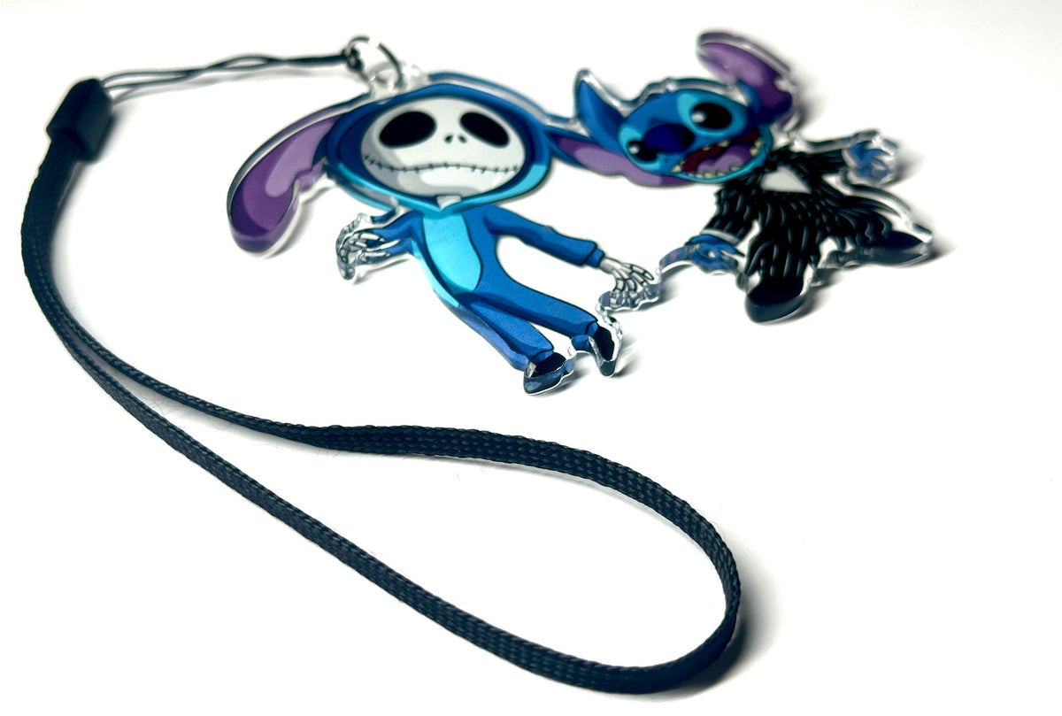 Blue alien and skeleton-costume duo acrylic wrist strap keychain on white background, angled product photo
