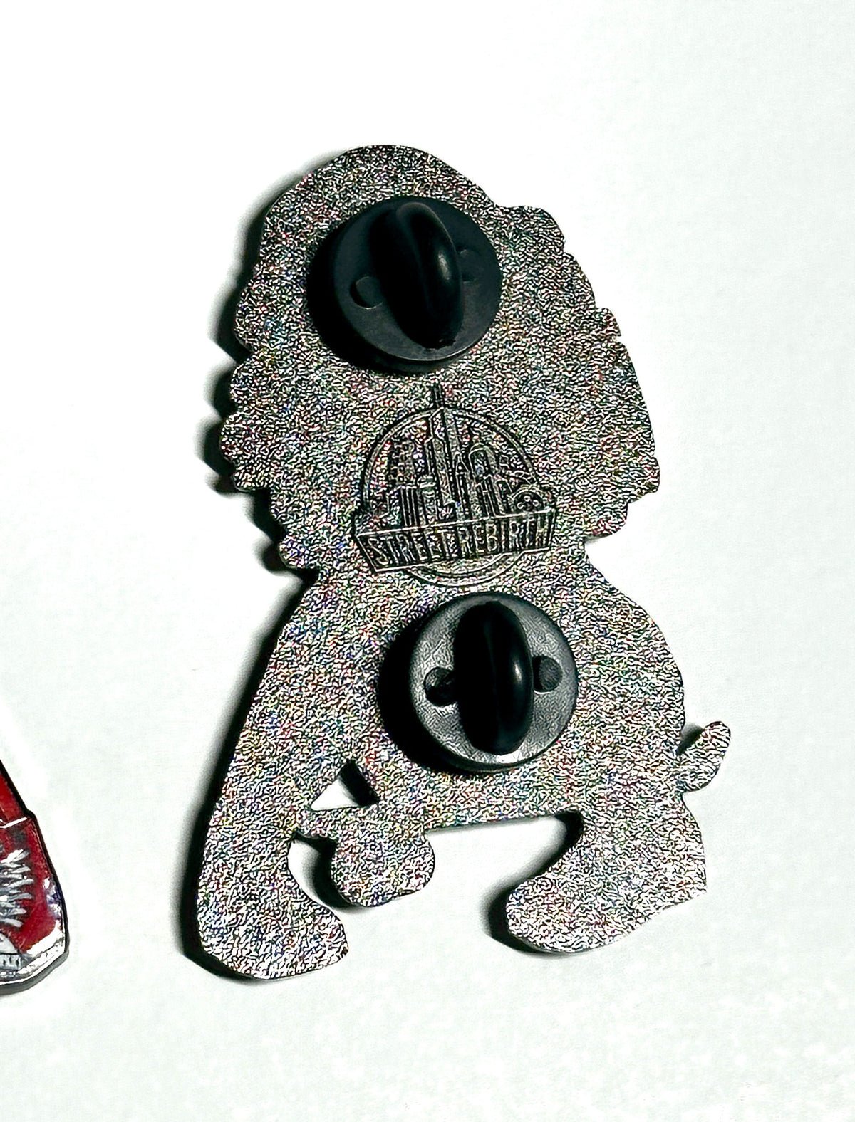 Silver metal two-post backing of bubblegum skater enamel pin
