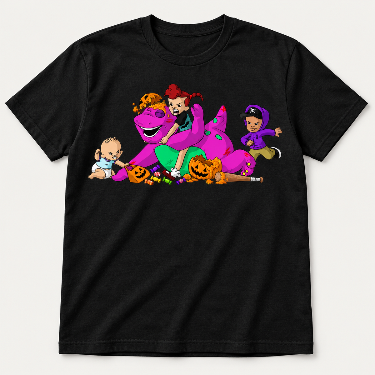 Black graphic T-shirt showing cartoon kids stealing a purple dinosaur's candy with broken jack-o-lanterns and scattered sweets.