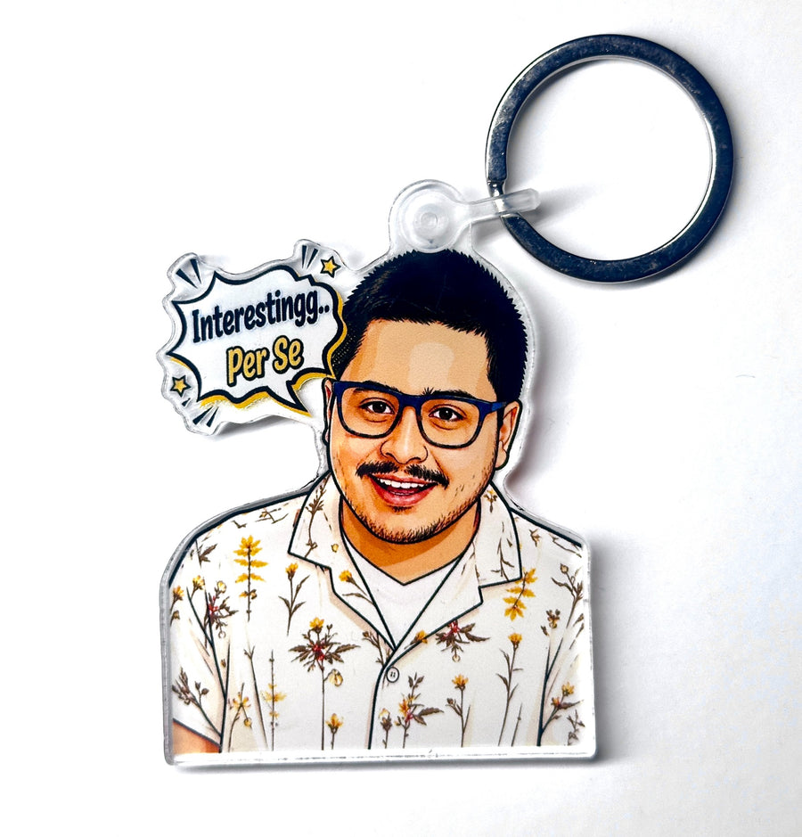 Funny reaction portrait acrylic keychain with glasses, floral shirt, and speech bubble reading Interestingg Per Se, front product photo