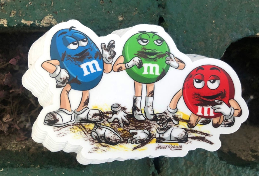Dark humor sticker of a cannibal chocolate candy character standing over a fallen friend