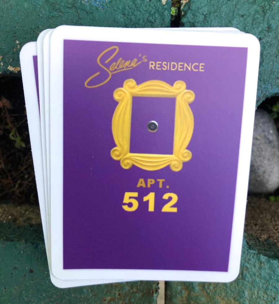 Purple apartment door with a gold picture frame and a Latina music icon signature above apartment 512
